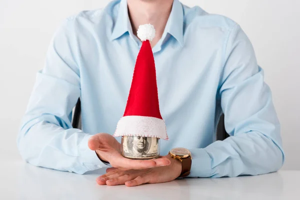 Cropped view of businessman holding jar with dollar banknotes and santa hat isolated on white — Stock Photo