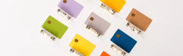 Панорамний знімок шаблонів кредитних карток біля готівкових рулонів ізольовано на білому — стокове фото