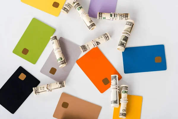 Vista superior de las plantillas de tarjetas de crédito con ahorros cerca de rollos de efectivo en blanco - foto de stock