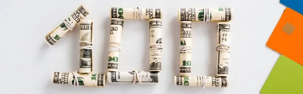 Panoramic shot of one hundred dollar banknotes in cash rolls on white — Stock Photo