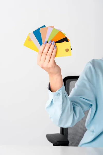 Abgeschnittene Ansicht einer Frau, die bunte Kreditkartenvorlagen in der Hand hält, isoliert auf weiß — Stockfoto