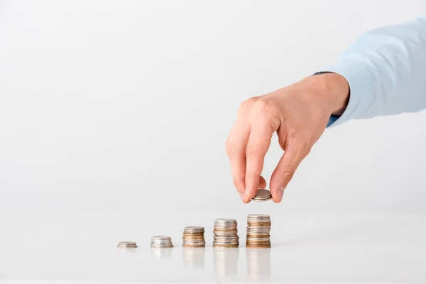 Cropped view of man taking coin from stack on white — Stock Photo