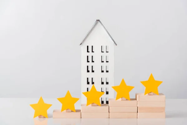 Casa de cartón cerca de estrellas en cubos de madera en blanco - foto de stock