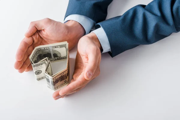 Cropped view of businessman near heart-shaped dollar banknotes on white — Stock Photo