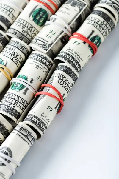 Dollar banknotes in cash rolls with rubber bands on white — Stock Photo