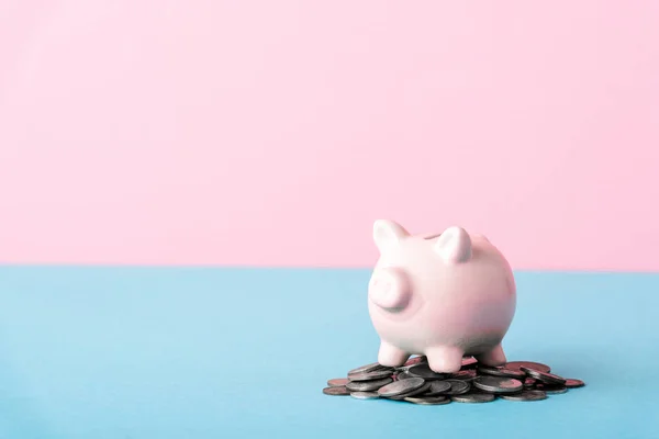 Pièces d'argent près de tirelire isolée sur bleu et rose — Photo de stock