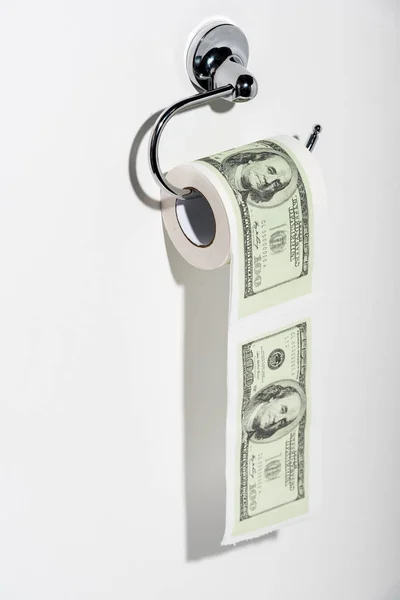 Toilet paper roll with dollar banknotes on white — Stock Photo