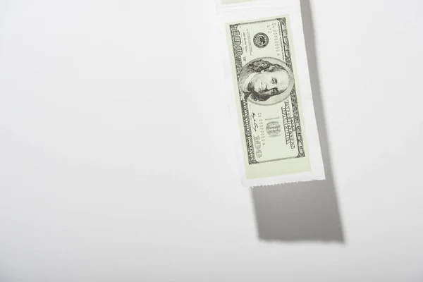 Toilet paper with dollar banknote on white with copy space — Stock Photo