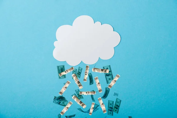 Weiße Wolke nahe fallendem Geld auf blauem Grund — Stockfoto