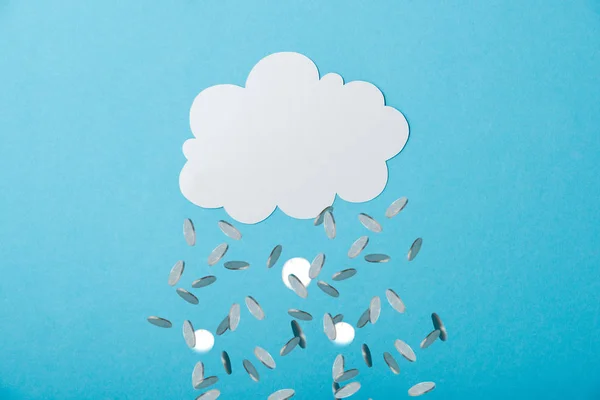 Порожня біла хмара біля падаючих срібних монет на синьому — стокове фото