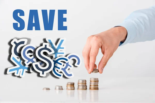 Cropped view of man touching stack of coins near save letters and on white — Stock Photo