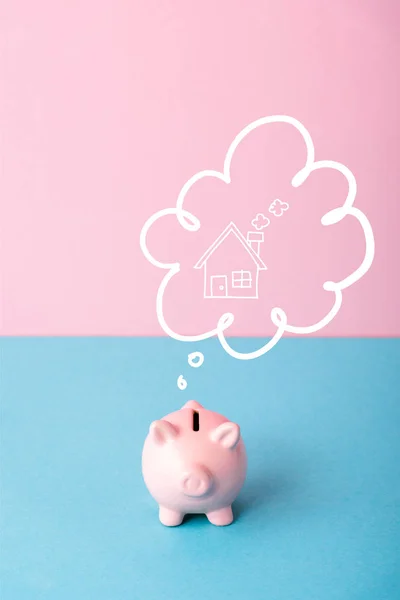 Alcancía cerca de burbuja pensamiento con casa en rosa y azul - foto de stock
