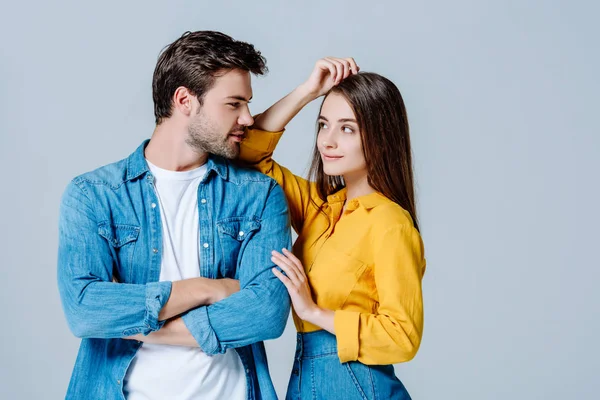Young couple in denim looking at each other isolated on grey — Stock Photo