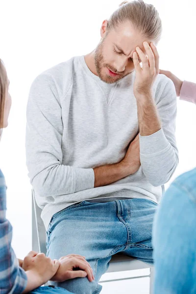 Support group helping sad man on chair isolated on white — Stock Photo