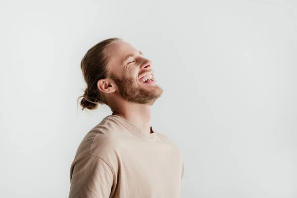 Feliz jovem bonito homem em roupa bege rindo isolado no branco — Fotografia de Stock