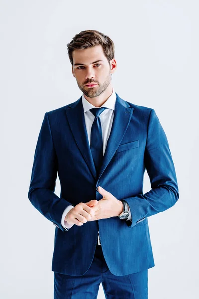 Красивый бизнесмен в синем костюме смотрит на камеру, изолированную на белом — стоковое фото