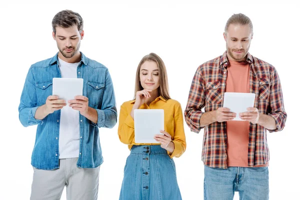 Tres jóvenes amigos usando tabletas digitales aisladas en blanco - foto de stock