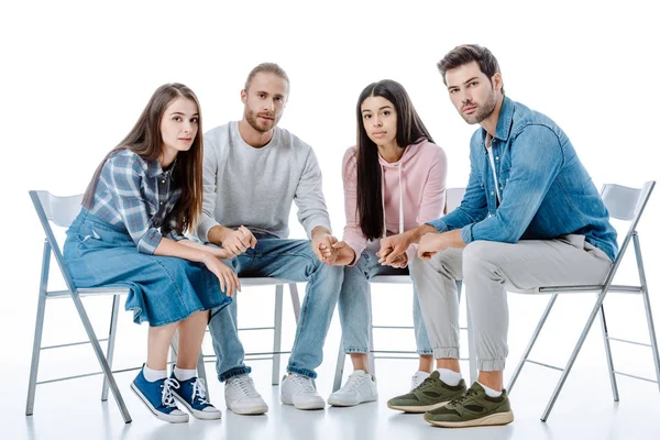 Grupo de apoyo multicultural sentado en sillas aisladas en blanco — Stock Photo