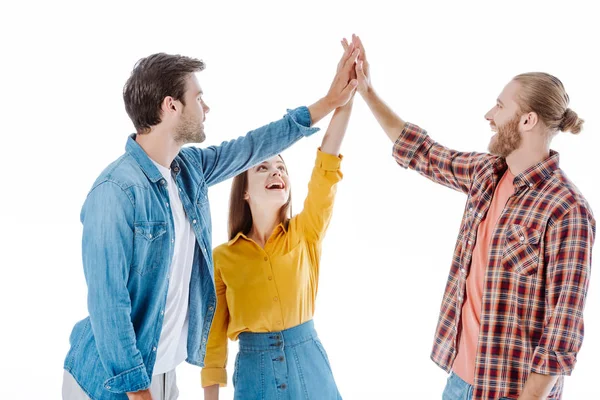 Щасливі три молодих друзі дають високі п'ять ізольовані на білому — стокове фото