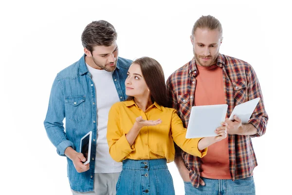 Tres jóvenes amigos usando tabletas digitales aisladas en blanco - foto de stock
