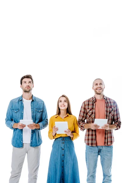 Drei junge Freunde halten digitale Tablets in der Hand und blicken isoliert auf weiß — Stockfoto