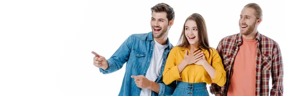 Tres jóvenes amigos riendo y señalando con el dedo aislado en blanco, plano panorámico - foto de stock