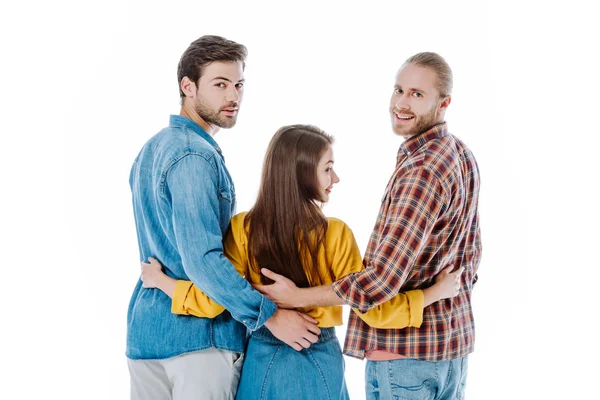 Vista posteriore di tre giovani amici sorridenti che si abbracciano isolati sul bianco — Foto stock