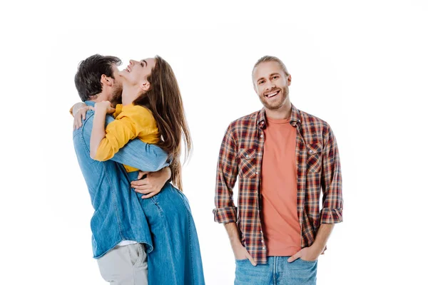 Feliz casal abraço perto sorrindo amigo isolado no branco — Fotografia de Stock