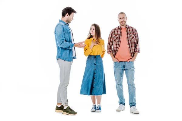 Vista completa de tres jóvenes amigos hablando aislados en blanco - foto de stock