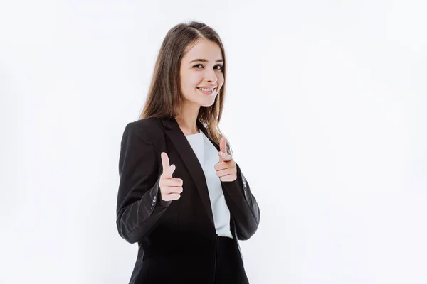 Улыбающаяся уверенная деловая женщина в костюме, указывающая пальцами на камеру, изолированную на белом — стоковое фото