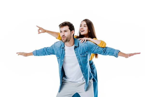 Jovem casal em jeans imitando voo e apontando com o dedo afastado isolado no branco — Fotografia de Stock