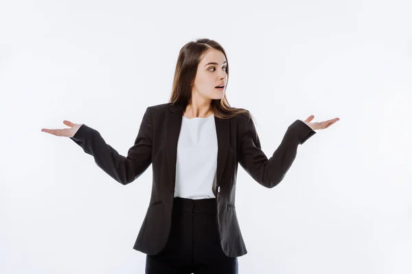 Confusa mujer de negocios en traje mostrando gesto de encogimiento aislado en blanco - foto de stock