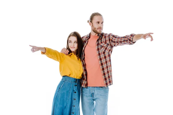 Young couple in casual outfit pointing with fingers away isolated on white — Stock Photo