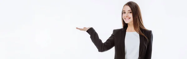 Sonriente mujer de negocios en traje apuntando con la mano aislada en blanco, plano panorámico - foto de stock