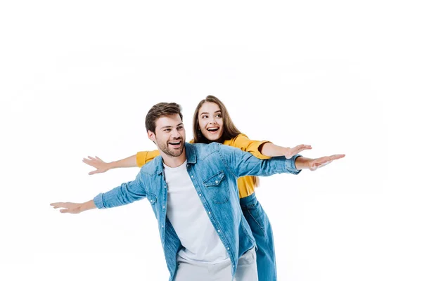 Feliz joven pareja en denim con los brazos abiertos aislados en blanco - foto de stock