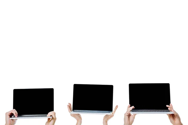 Cropped view of young friends holding laptops with blank screens isolated on white — Stock Photo