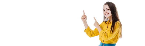 Glückliches attraktives Mädchen, das mit isolierten Fingern auf weiße, panoramische Aufnahme zeigt — Stockfoto