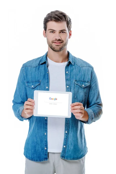 KYIV, UKRAINE - 12 de agosto de 2019: homem sorridente em camisa jeans segurando tablet digital com google homepage isolado em branco — Fotografia de Stock