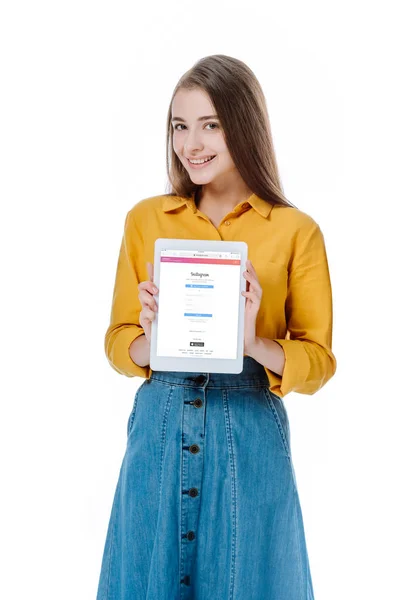 KYIV, UCRAINA - AGOSTO 12, 2019: ragazza sorridente in gonna di denim con tablet digitale e app Instagram isolata su bianco — Foto stock