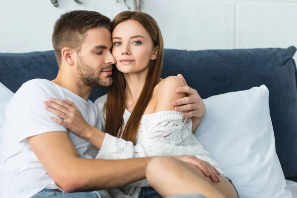 Hombre guapo con los ojos cerrados abrazando a mujer atractiva en suéter - foto de stock