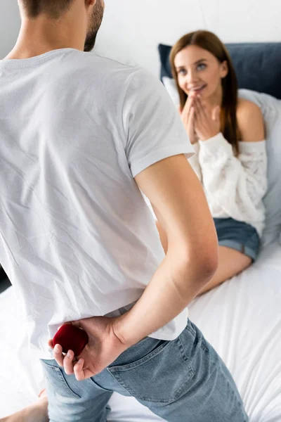 Corte vista de homem segurando caixa e mulher sorrindo olhando para ele — Fotografia de Stock