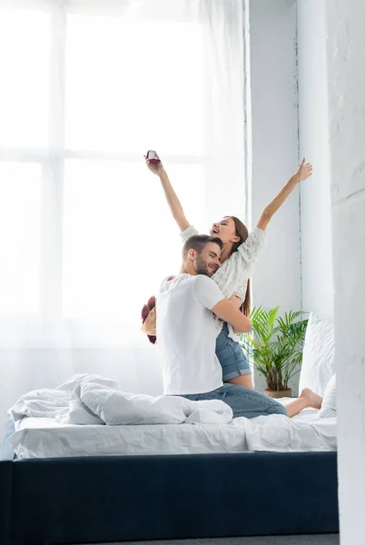 Handsome man hugging attractive and smiling woman with engagement ring — Stock Photo