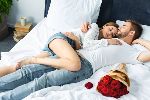 Привлекательная женщина и красивый мужчина с закрытыми глазами лежит в постели — стоковое фото