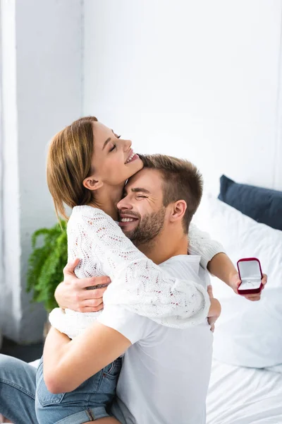 Handsome man hugging smiling woman with engagement ring — Stock Photo