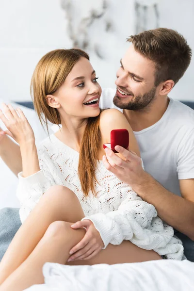Handsome man doing marriage proposal to shocked and attractive woman — Stock Photo