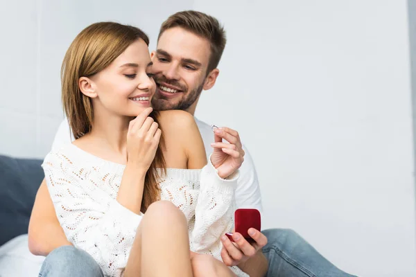 Homem bonito fazendo proposta de casamento a mulher sorridente e atraente — Fotografia de Stock