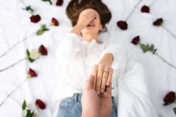 Cropped view of man holding hand of smiling woman — Stock Photo