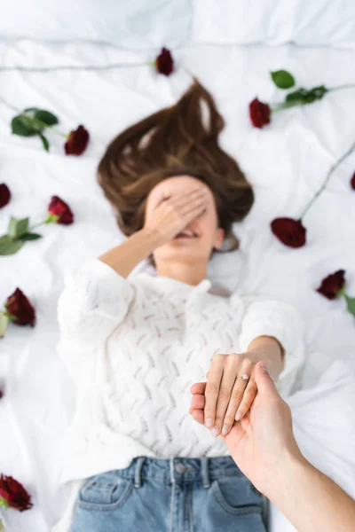 Обрезанный вид мужчины, держащего за руку улыбающуюся женщину — стоковое фото