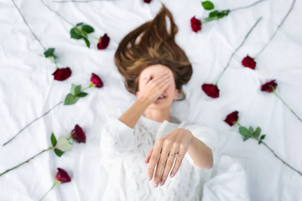 Top view of smiling woman showing engagement ring and obscuring face — Stock Photo