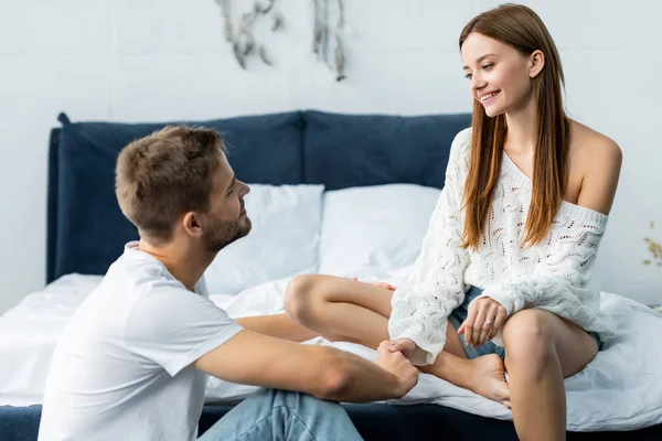 Attractive woman holding hands with smiling and handsome man — Stock Photo